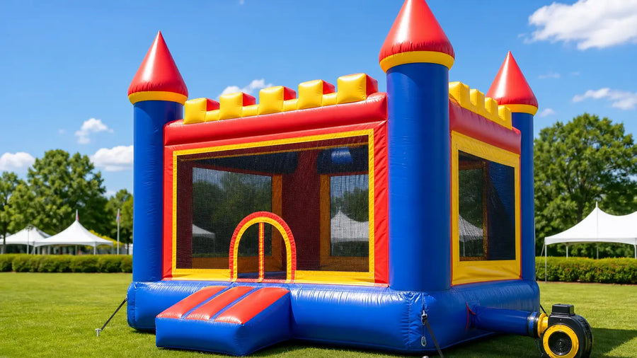 Commercial-grade castle bounce house with blower and anchor stakes at an outdoor event