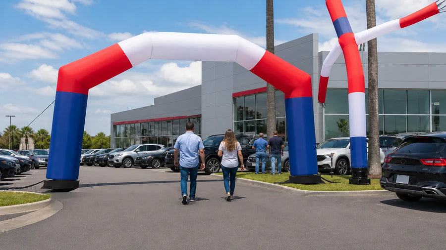 Custom-branded advertising inflatable arch and air dancer outside a car dealership lot