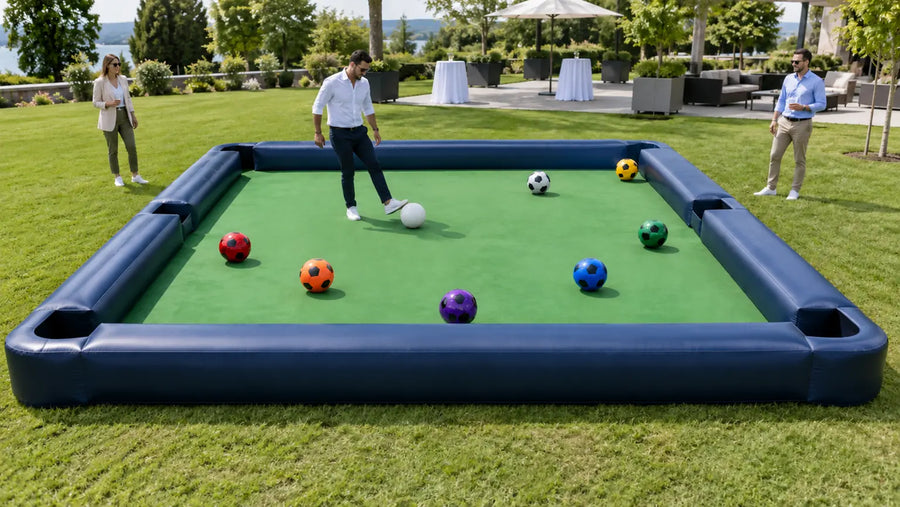 Illustrative scene of an adult preparing a foot shot on an inflatable soccer-pool field at an outdoor event.